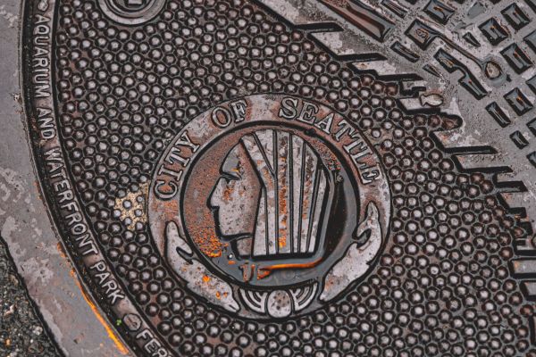 This image shows a manhole cover in Seattle, featuring the words 